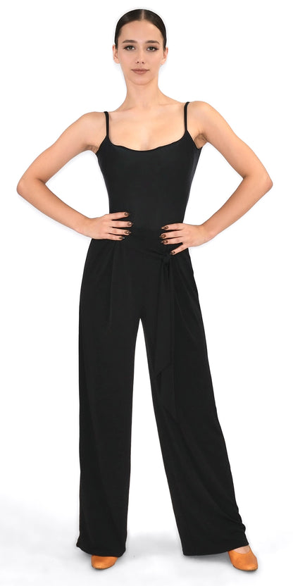 Woman wearing a black sleeveless top and high-waisted pants on a white background